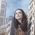 Giantess appears behind a skyscraper
