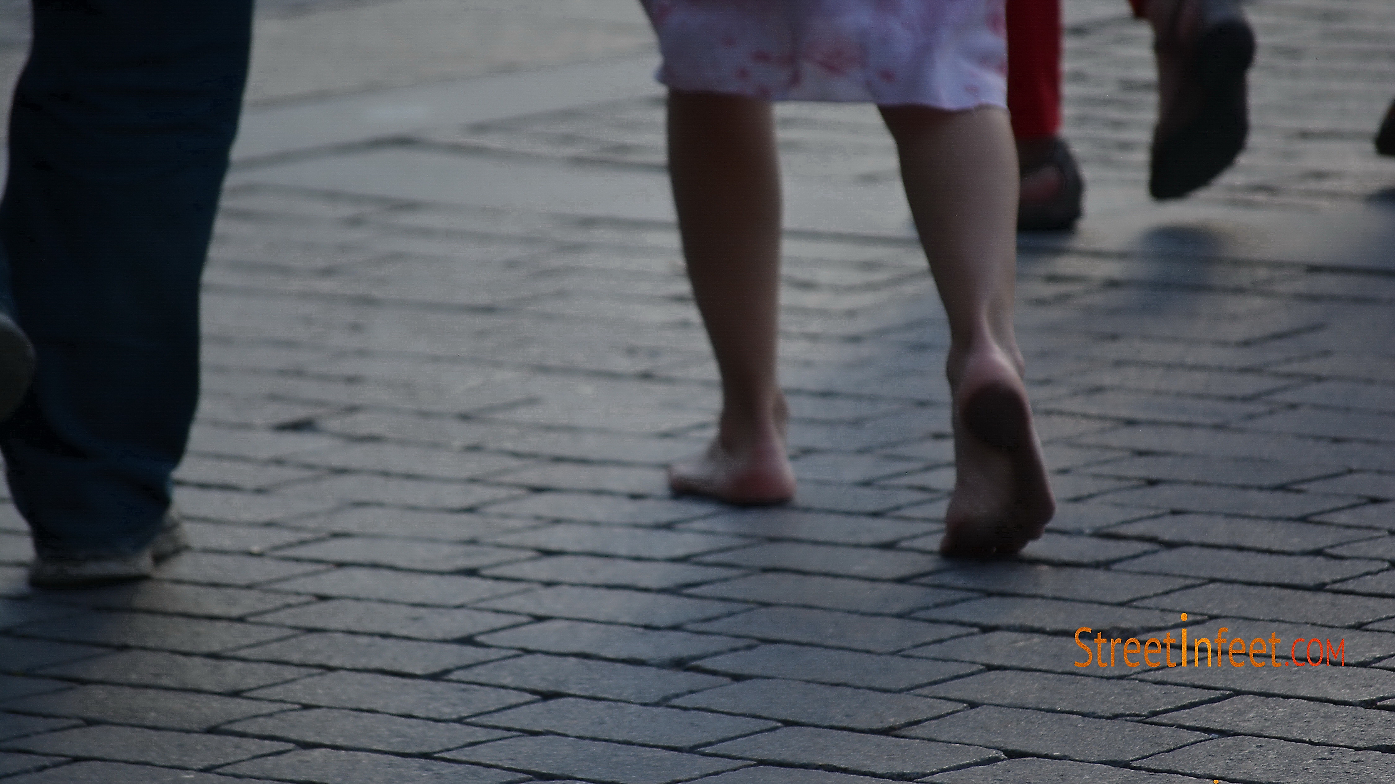 Barefoot girl walking in street whith dirty feet by 